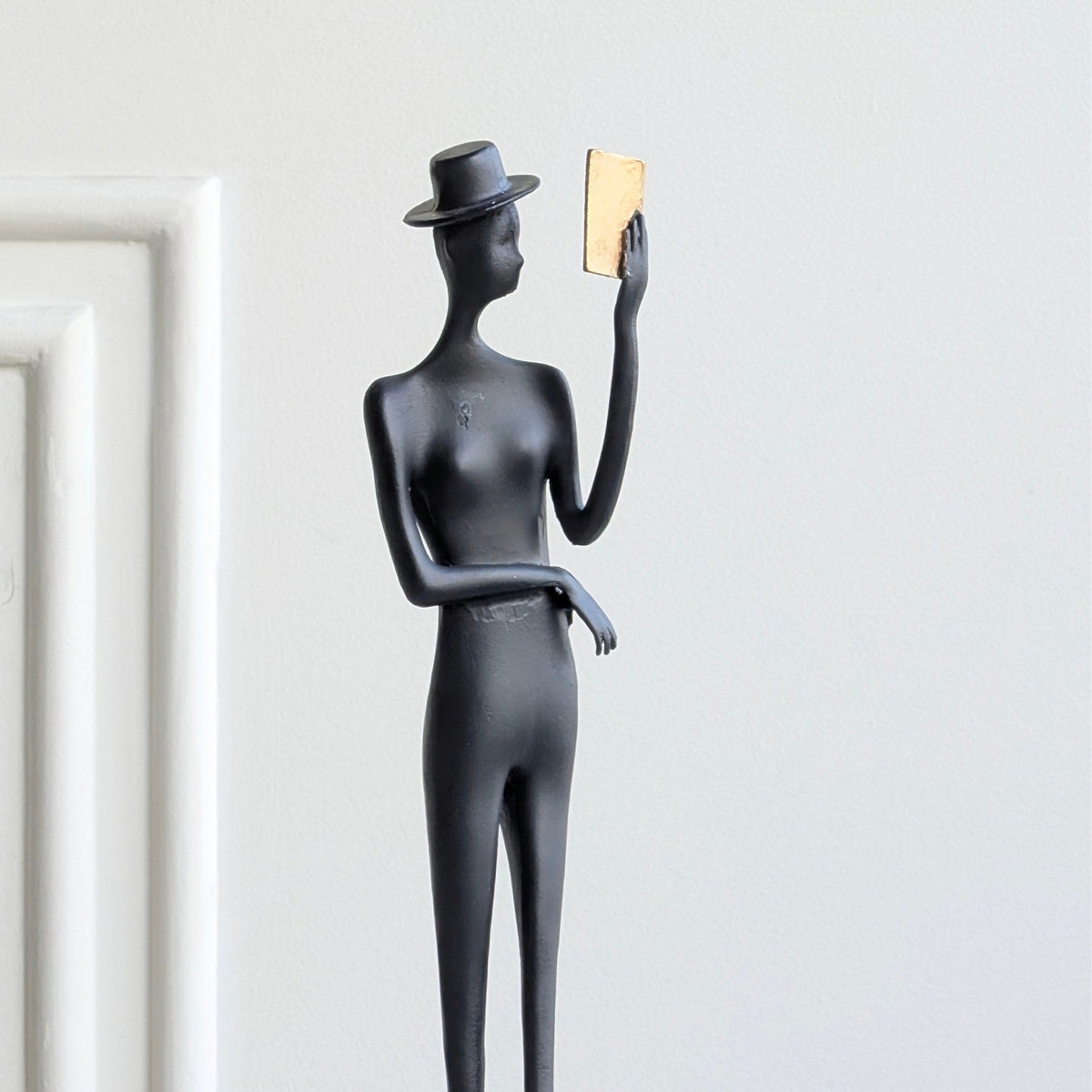 Poise black metal gentleman figurine close front view with gold accent