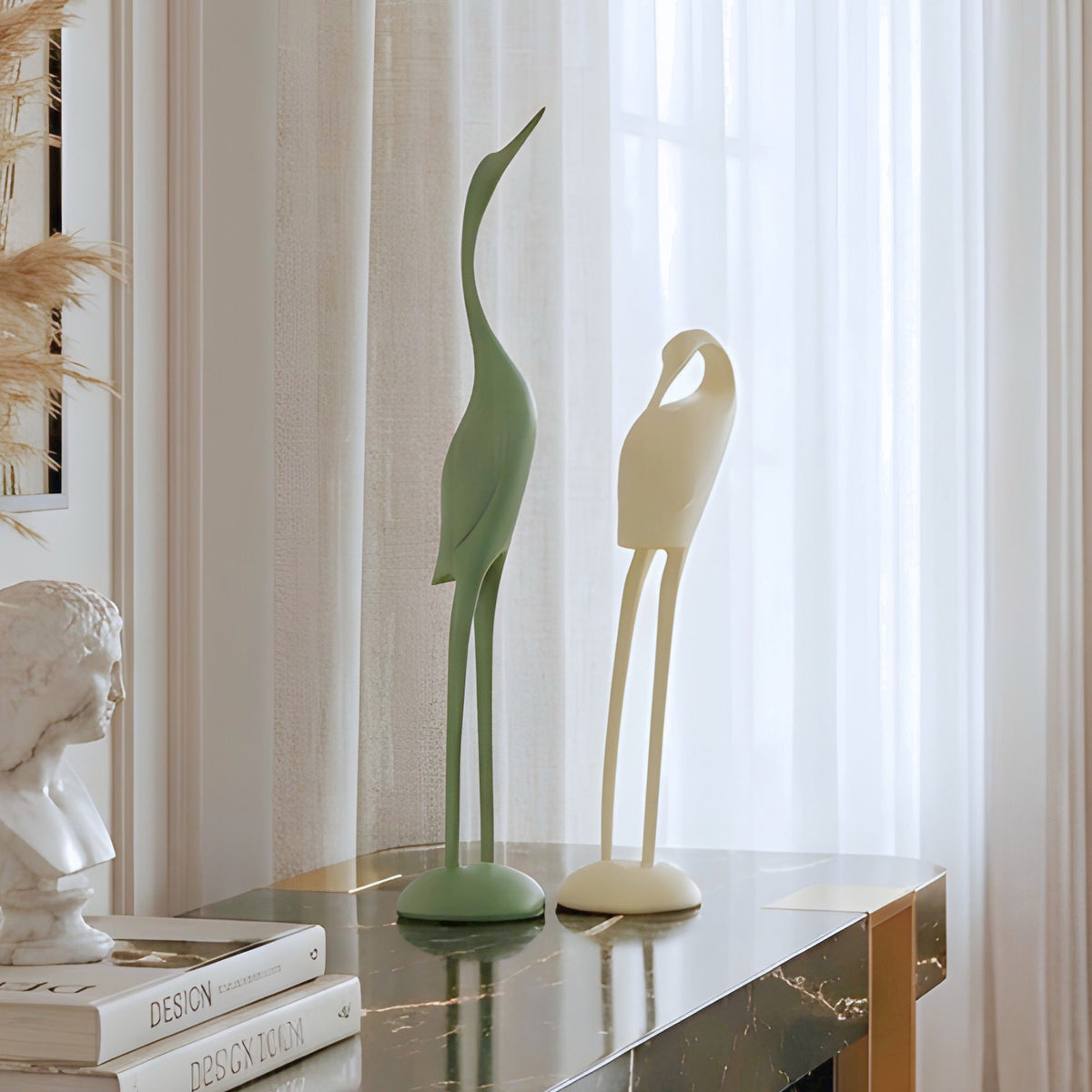 Poise pair of green and ivory resin bird sculptures styled on a luxury living room console table