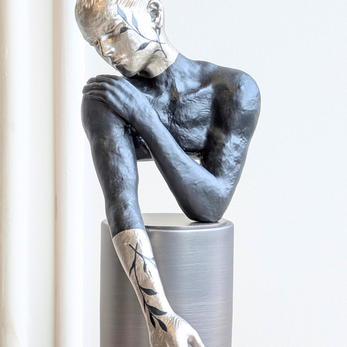 Poise resting woman figurine highlighting its black and silver finish