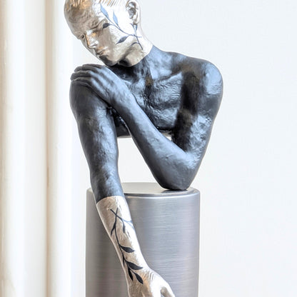Poise resting woman figurine highlighting its black and silver finish
