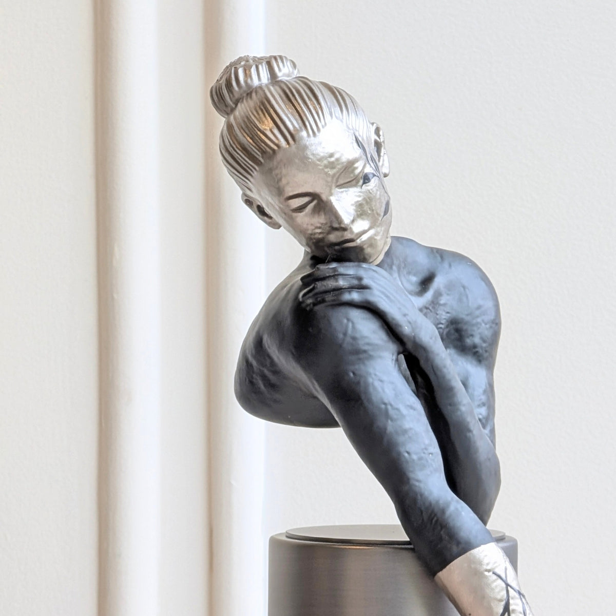 Poise woman showpiece with detailed silver face and graceful resting pose