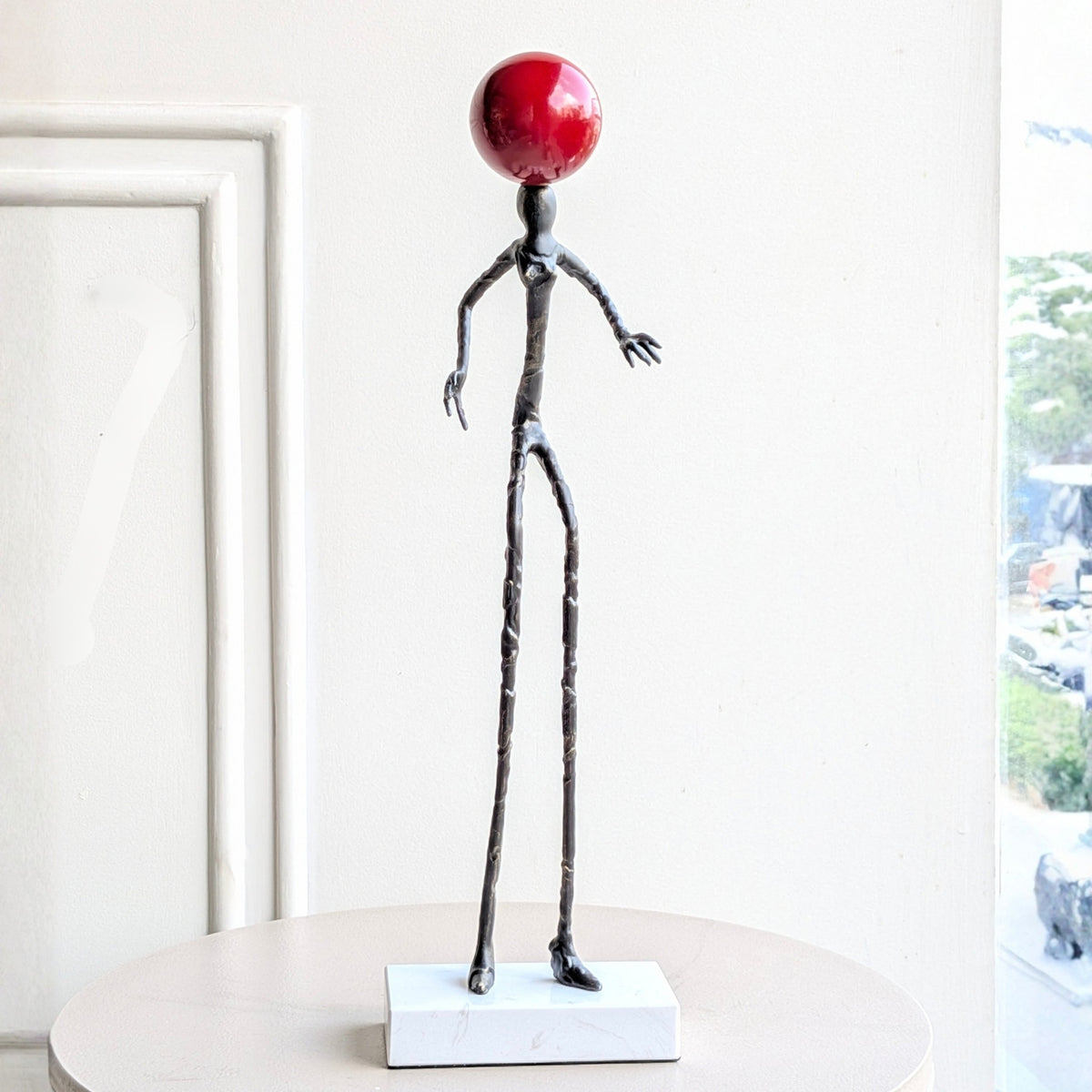 Redshift abstract black metal human sculpture on a white marble base