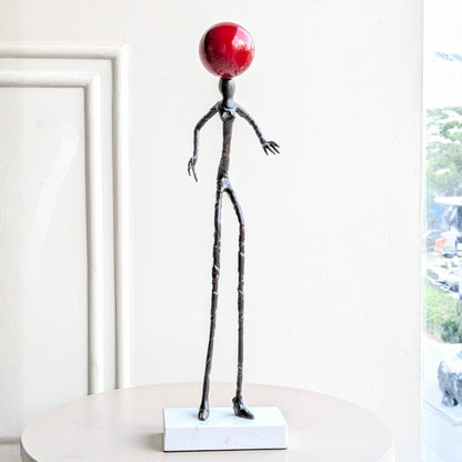 Redshift abstract black metal human sculpture on a white marble base