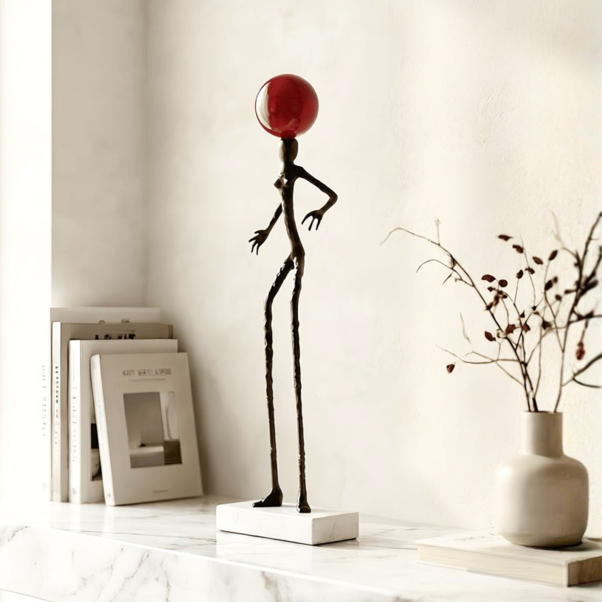 Redshift black metal human showpiece with red orb styled on a console table
