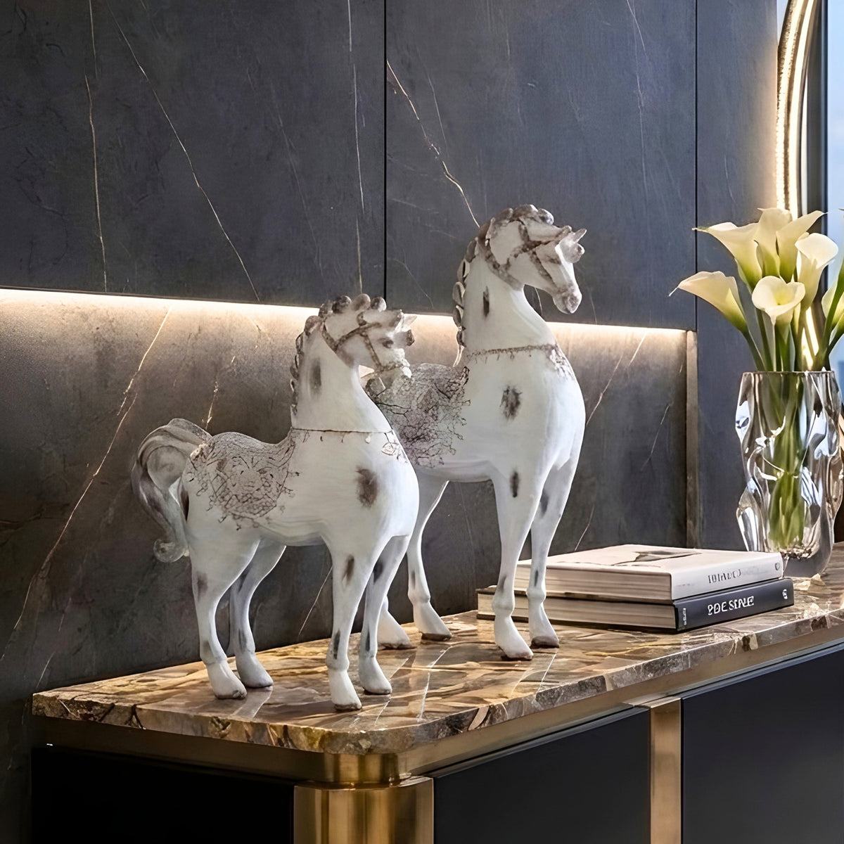 Regalia resin horse showpieces styled on a dark marble console with books and flowers