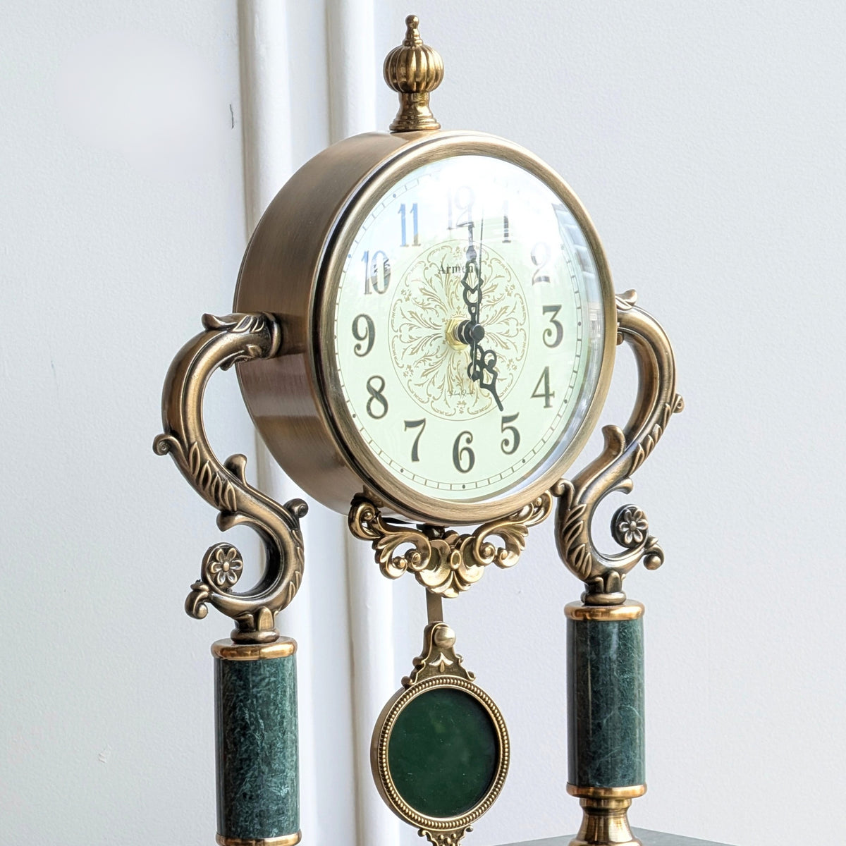 Regency marble and metal table clock showing antique gold detailing and green marble columns