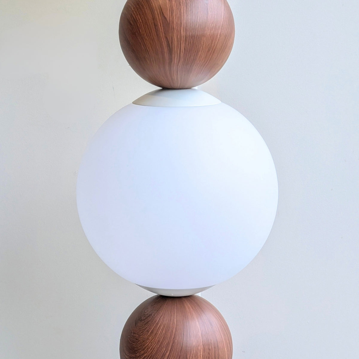 Close-up of the Solstice frosted glass globe and wood-grain metal detail
