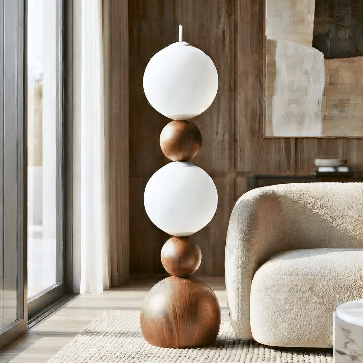 Solstice sculptural glass globe floor lamp beside a cream armchair in a modern living room