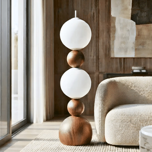 Solstice sculptural glass globe floor lamp beside a cream armchair in a modern living room