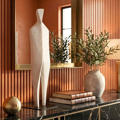 Stature tall abstract figure sculpture styled on a luxury entryway console with mirror