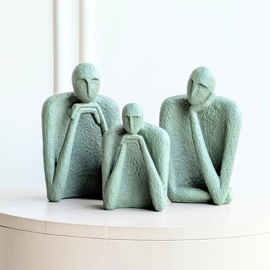 The Contemplatives sage-green abstract human figurine set styled on a console table