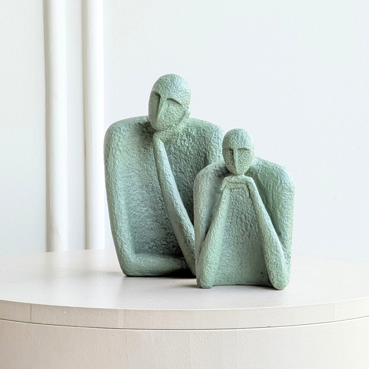 The Contemplatives sculptural human figurines styled on a curved console