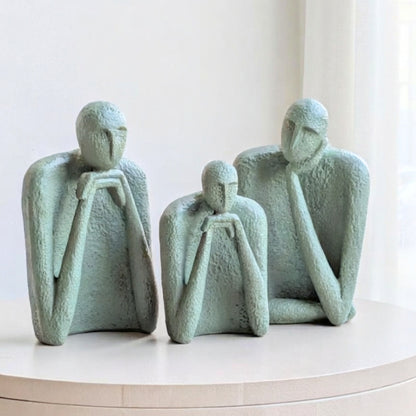 The Contemplatives set of three sage-green resin figurines displayed together