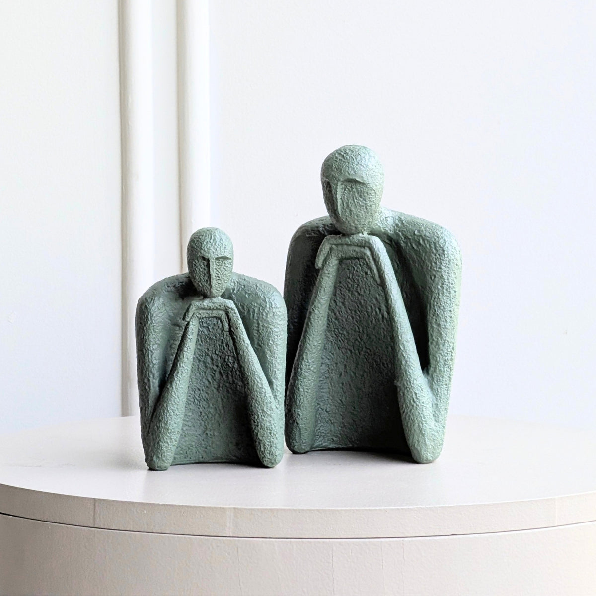 Two sage-green abstract figures from The Contemplatives set displayed together
