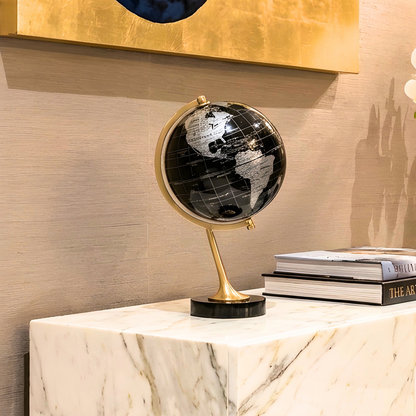 The World black globe showpiece with gold frame on a sideboard