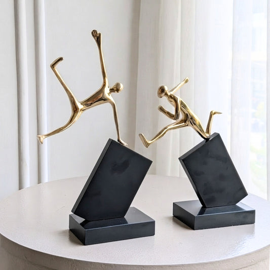 Velocity gold-tone metal running and jumping figurines on black marble bases