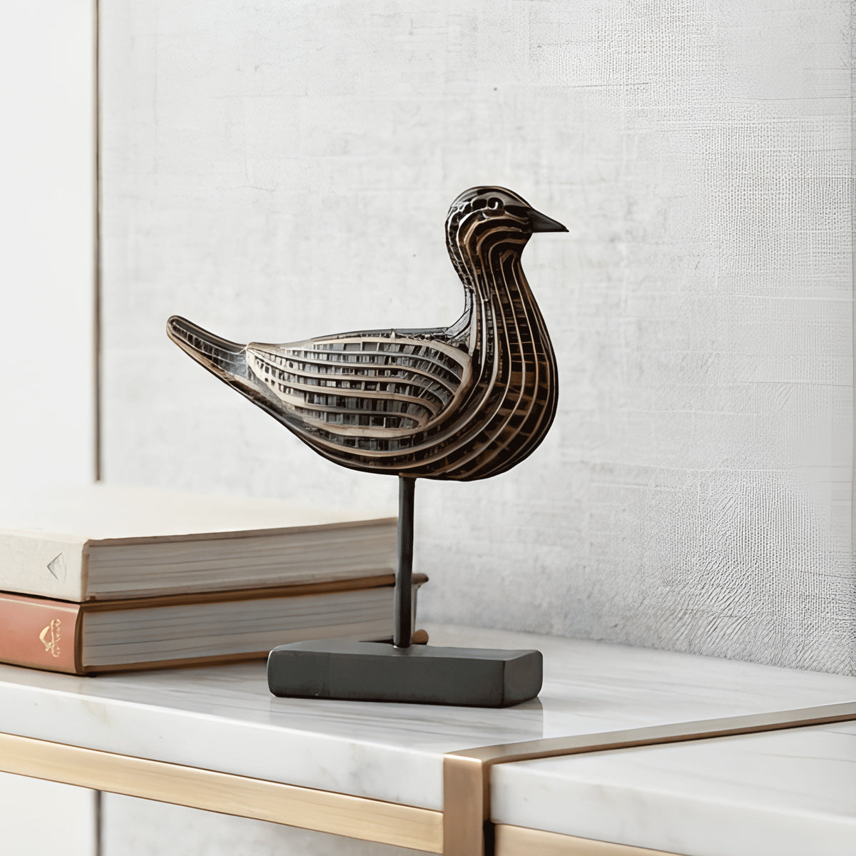 Sculptural resin bird figurine styled beside books for shelf decor